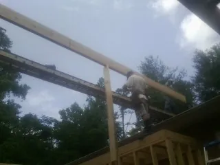 Carpenter setting a ridge beam over a new addition frame — Ice Dam Removal by Roofing Brothers in Kendrick