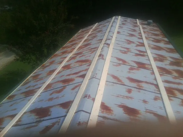Rusted metal roof panels with new wood purlins before replacement — Storm Damage Roof Repair in Kendrick by Roofing Brothers