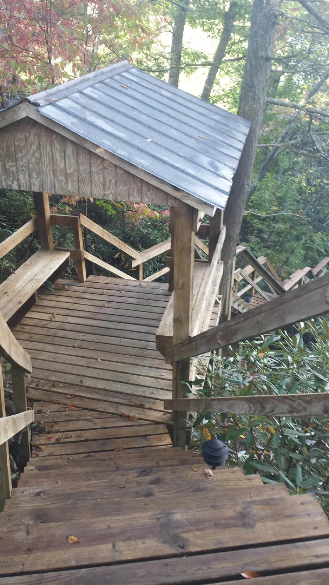 Metal roofed shelter over wooden steps on a wooded walkway — Skylight Repair & Installation work by our crew in Kendrick