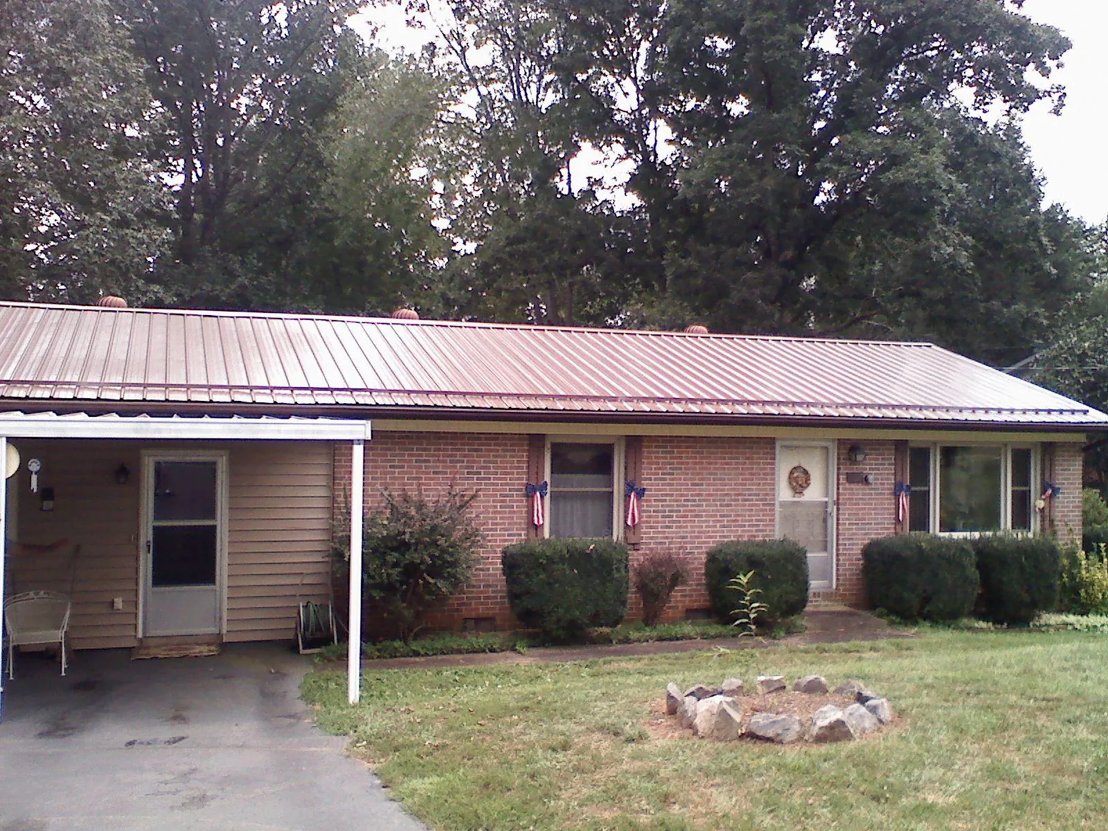 Bronze metal roof and carport on a brick ranch home — Roof Repair work by our crew in Kendrick